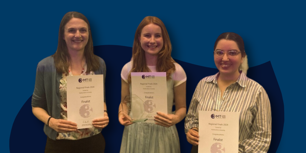 Three people holding certificates. The person in the middle is holding an award