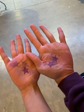Two hands with star stamps on palms