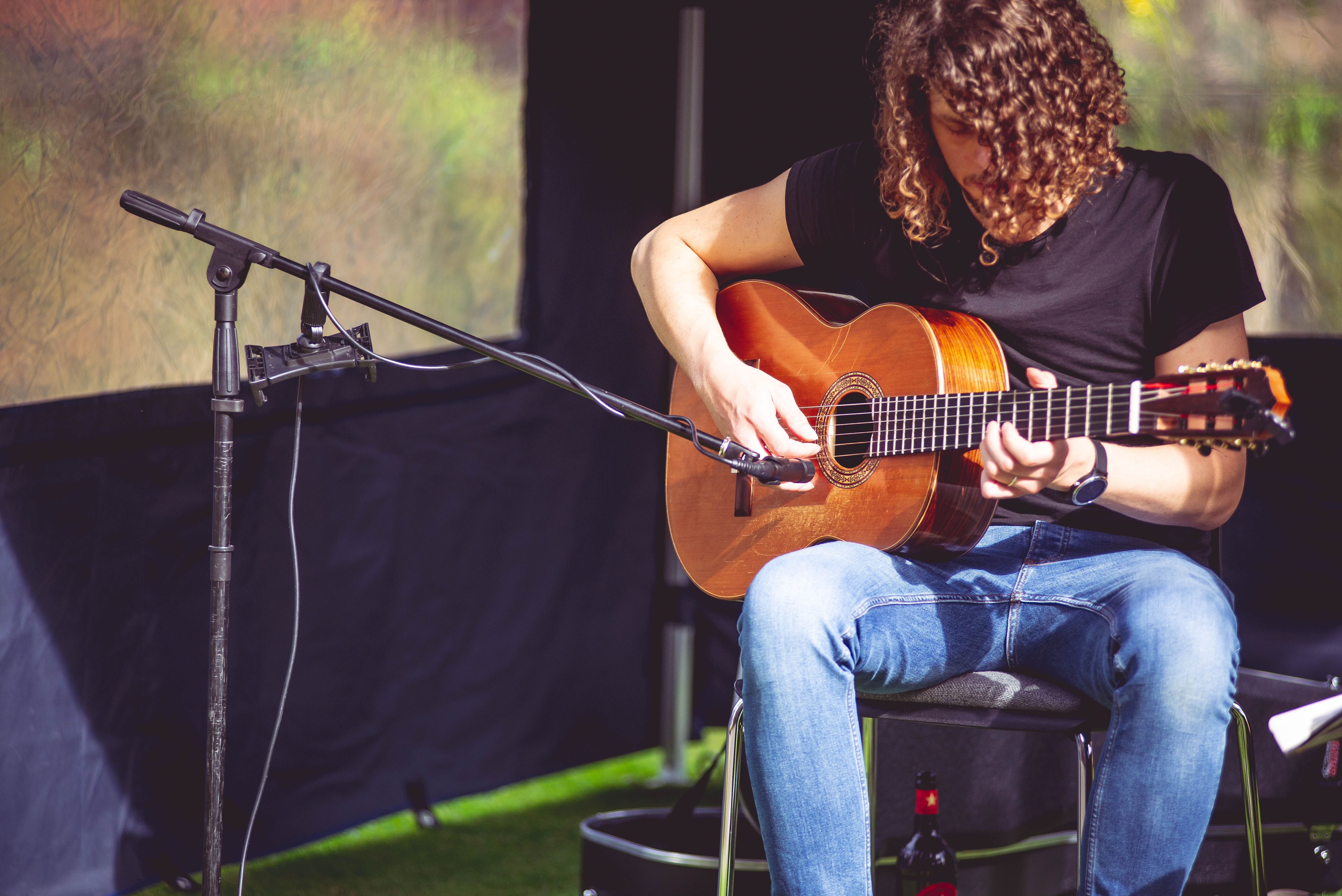 Student playing guitar on campus