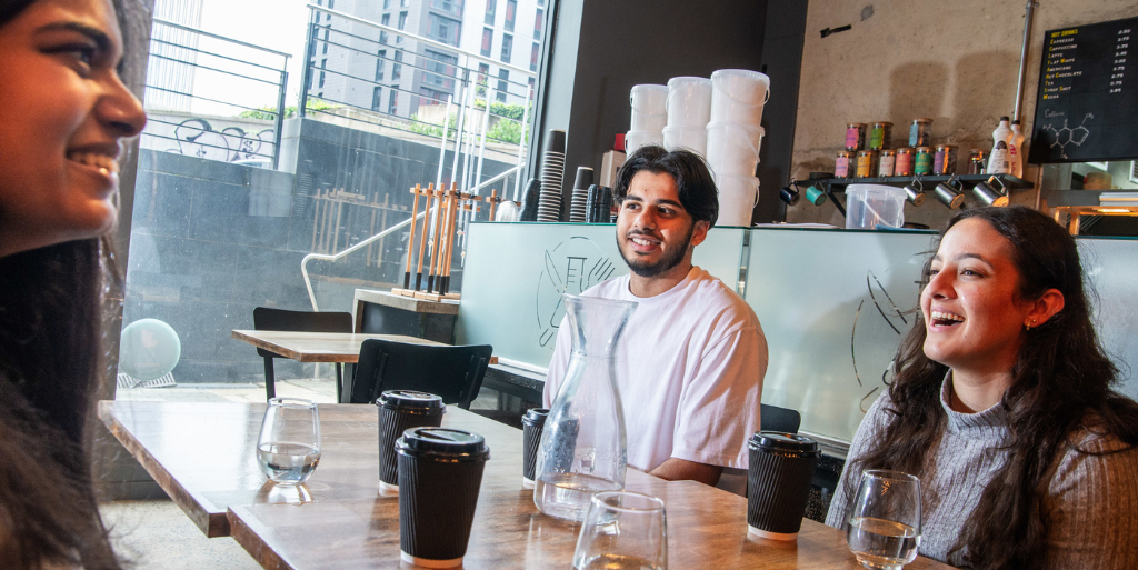 Three friends sat round a table with coffees