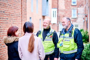 Two University security team chatting to two students