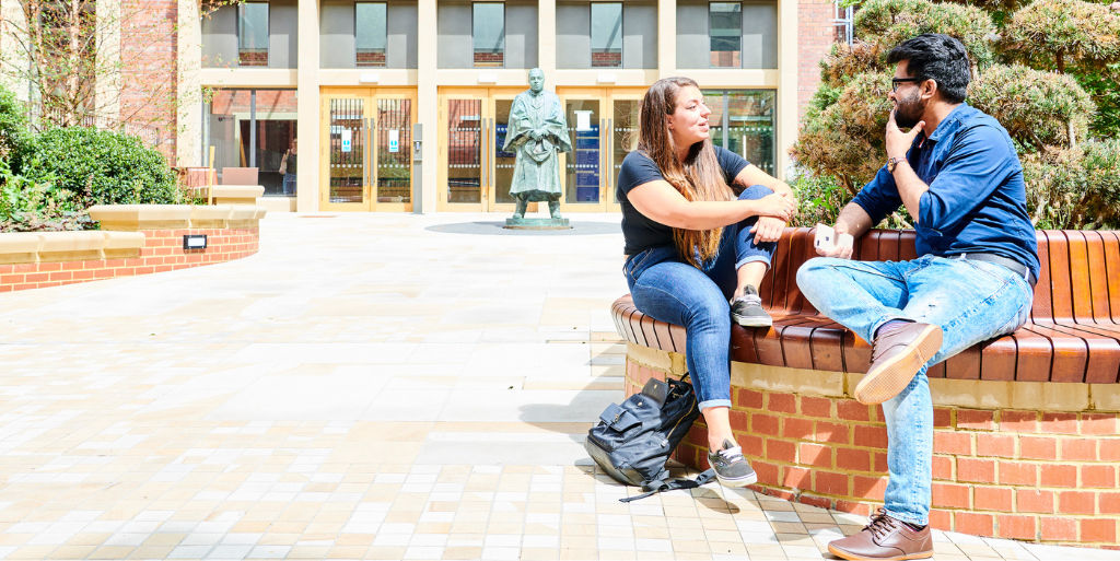 Two students sat outside chatting