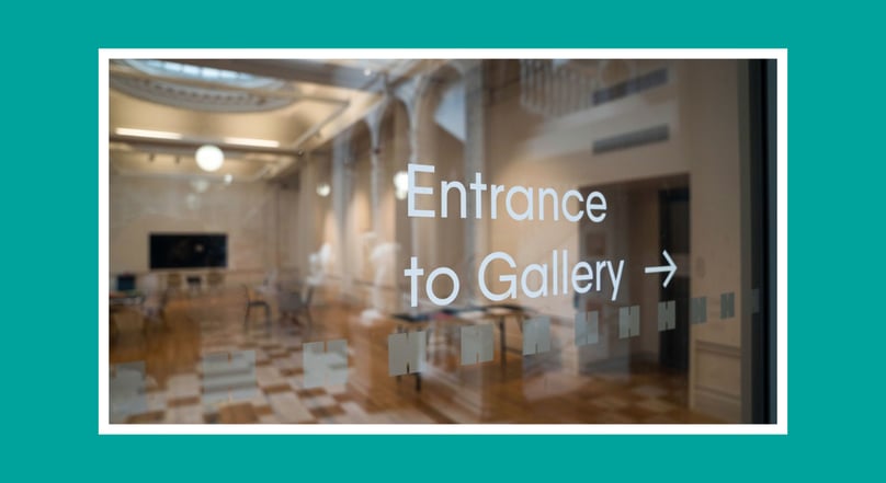 Glass entrance to a gallery with text reading “Entrance to Gallery” and an arrow.