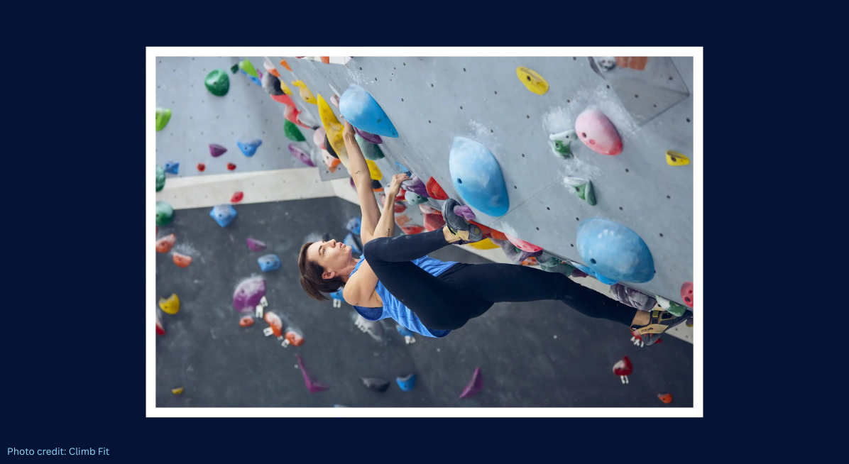 Person bouldering on an indoor climbing wall with colourful holds.