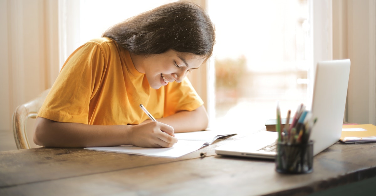 woman-in-yellow-shirt-writing-on-white-paper-3807755