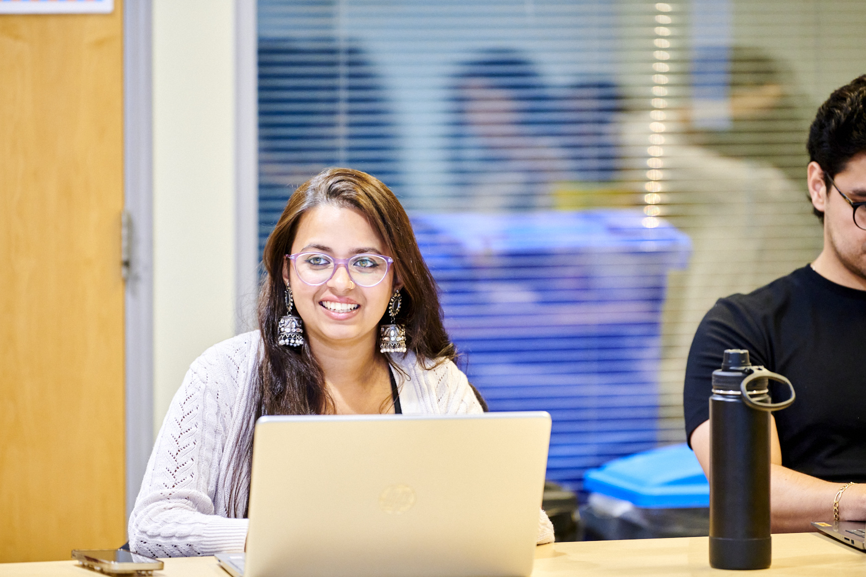 Nandita sits with laptop smiling